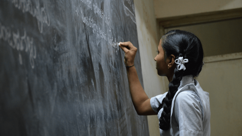 Girl writing on a blackboard