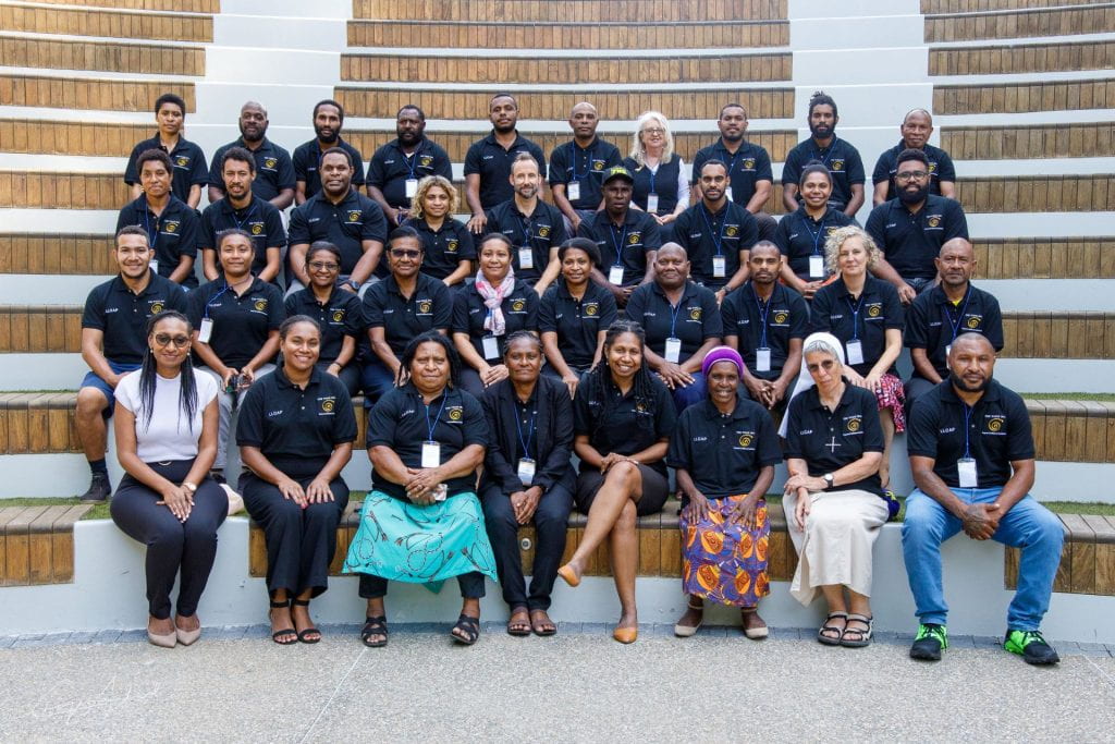 PNG group photo with 37 participants sitting on stairs