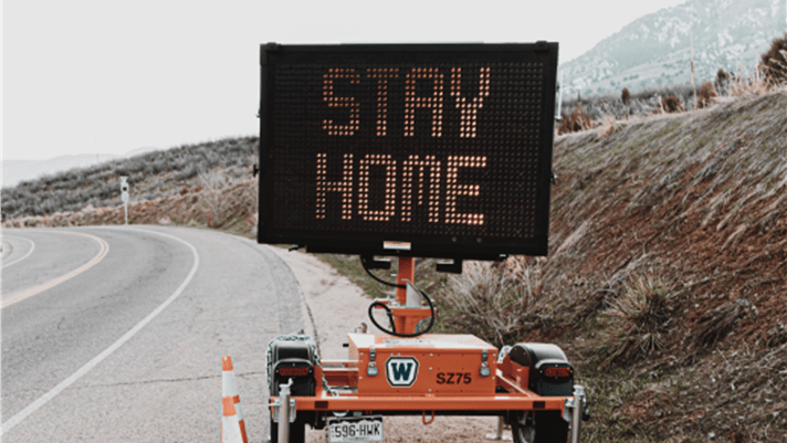 A sign on the road saying "Stay home"