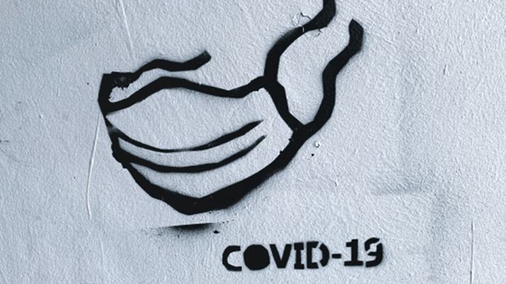 COVID-19 and a drawing of a mask on a wall