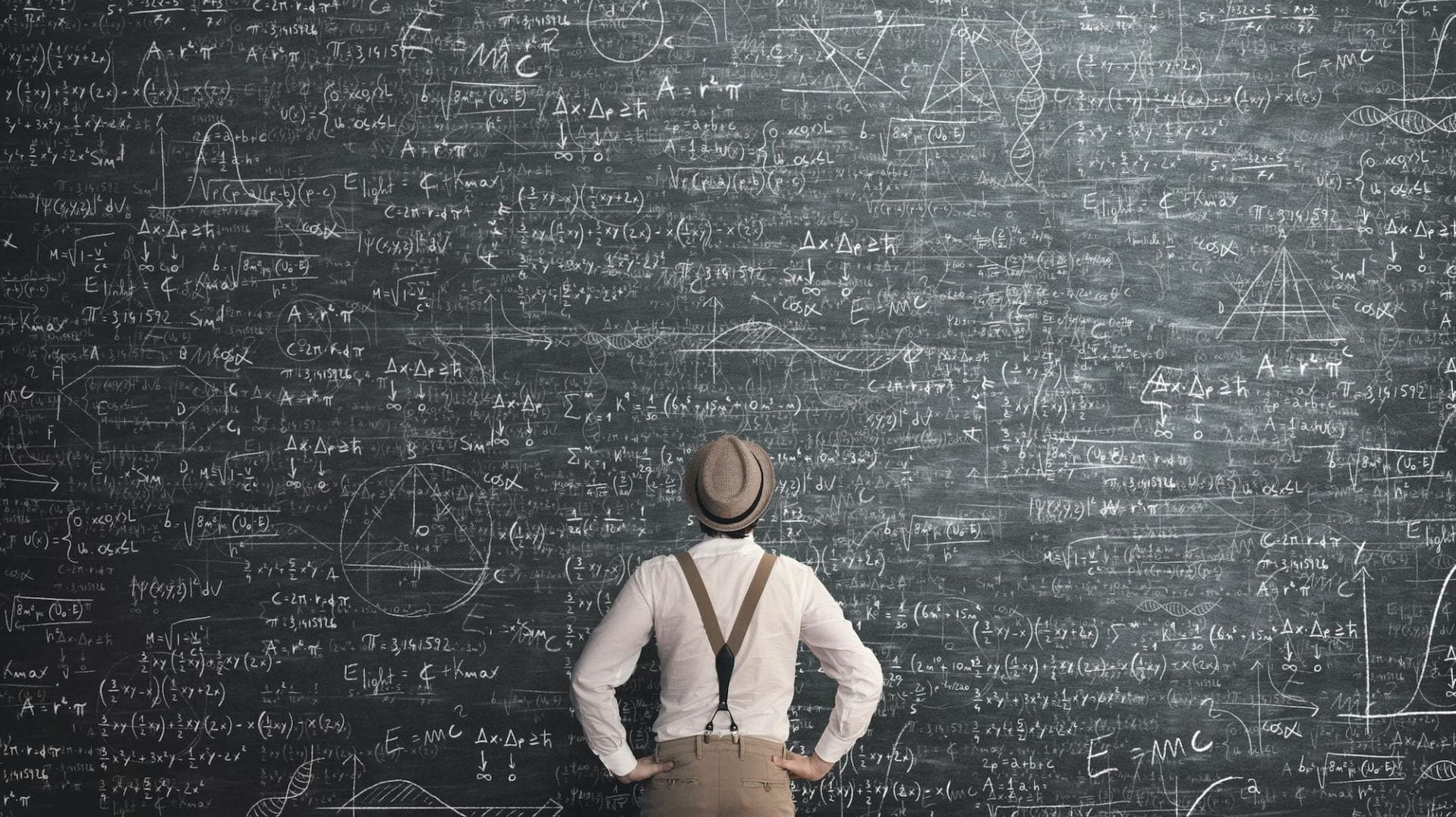 A person looking up at a chalkboard filled with complicated equations 