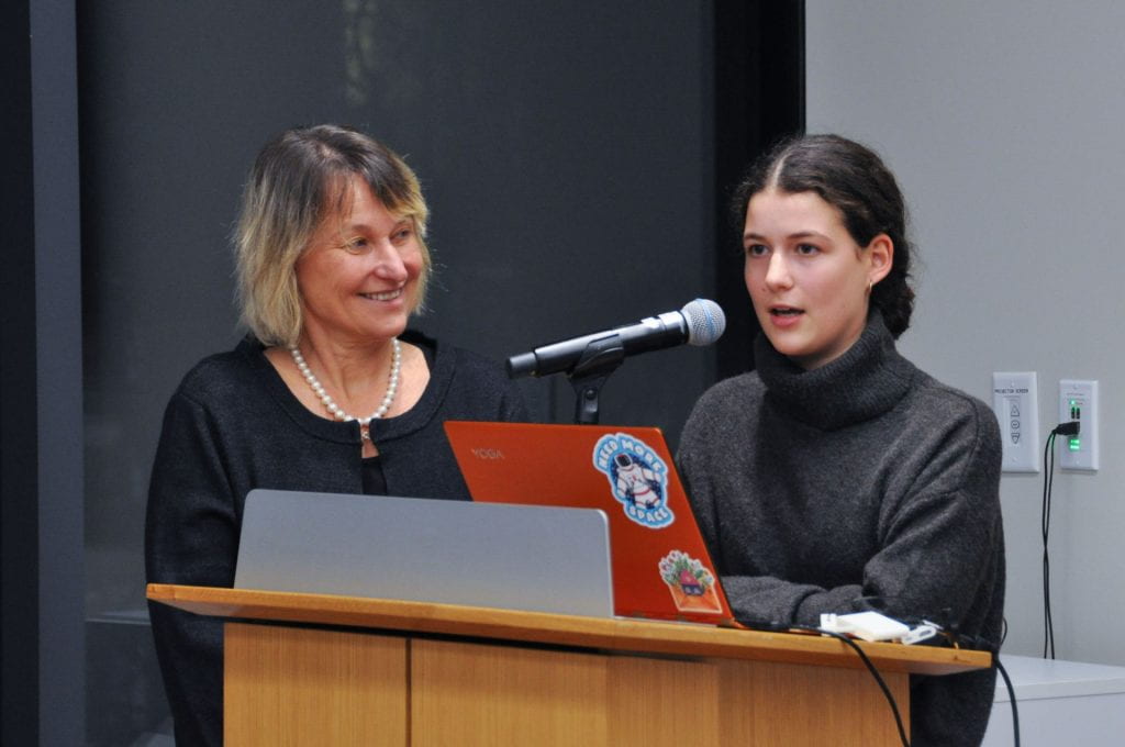 Sasha Segal speaks into microphone with mother, Olga Yulikova smiling off to the side
