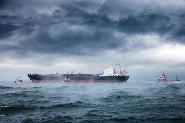 A barge in stormy waters with ominous clouds above and misty water