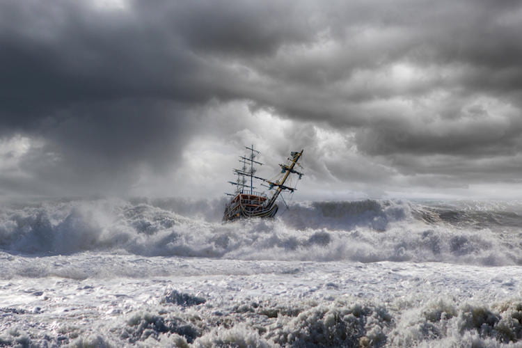 A ship in the middle of stormy seas with gray ominous clouds