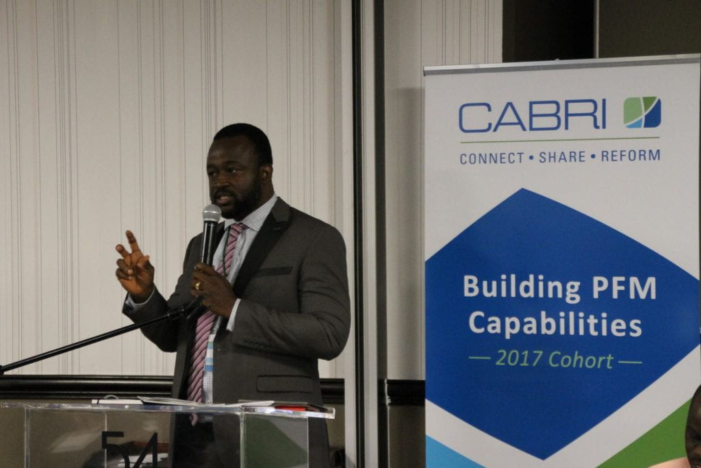 Liberia participant presenting with CABRI Building PFM Capabilities signage behind him
