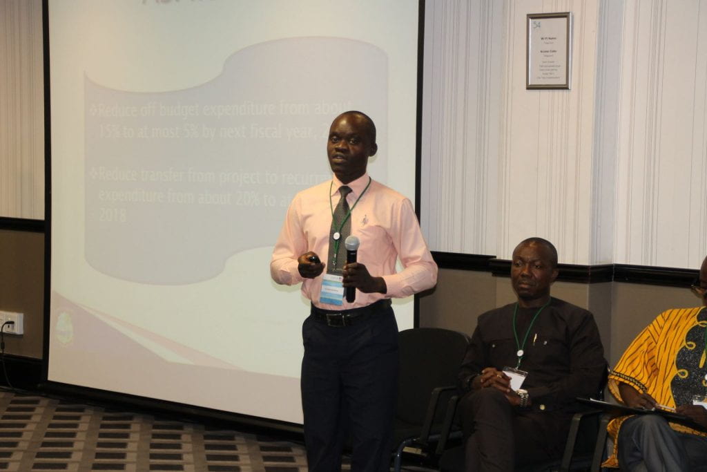 Liberia participant presenting with slides behind him