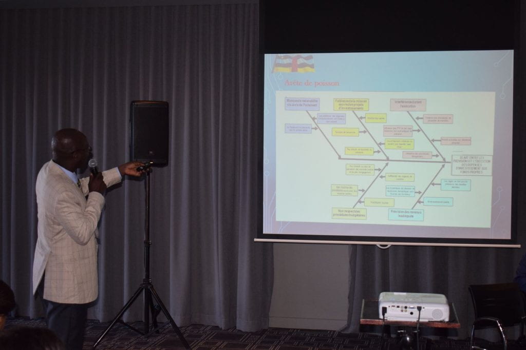 Central African Republic participant presenting and pointing to the fishbone diagram displayed on projector