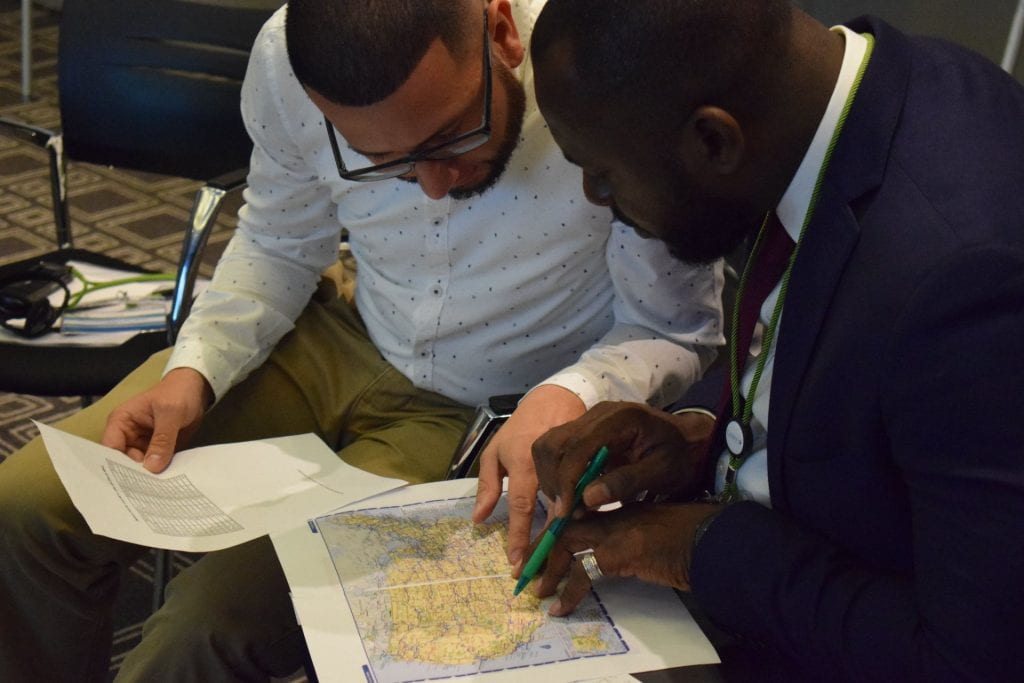 CABRI Ghana team working looking and pointing at a map of the United States