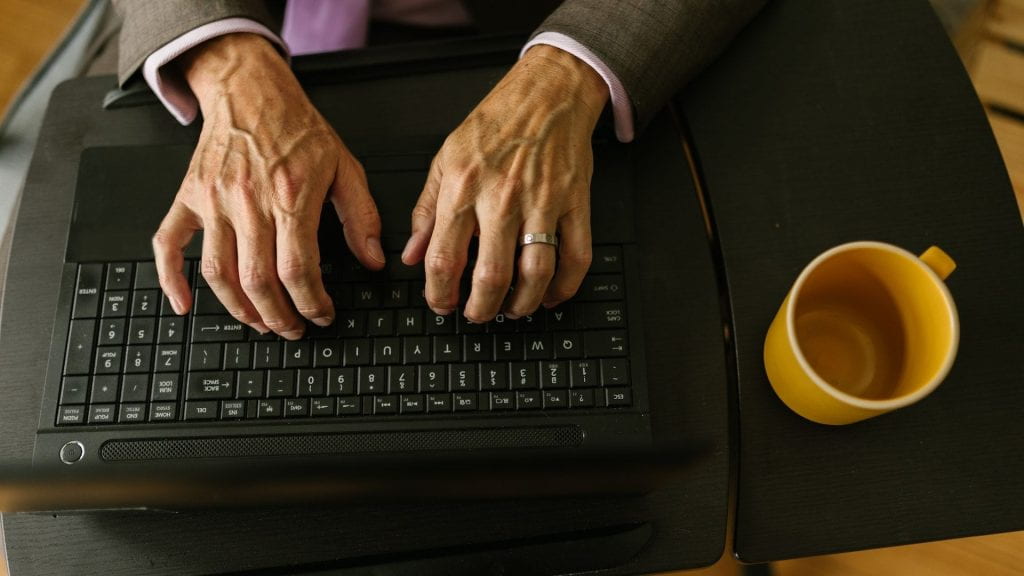Hands typing on a computer