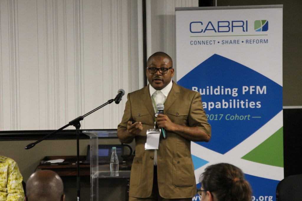 Ghana teammate presenting with CABRI PFM signage behind him