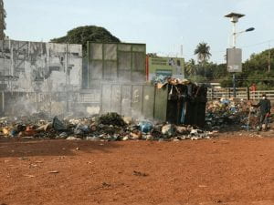 an image of trash burning in an open trash can outside a building