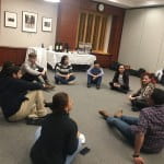 Participants sitting on the floor talking in a circle
