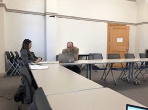 two individuals sitting in a big meeting room
