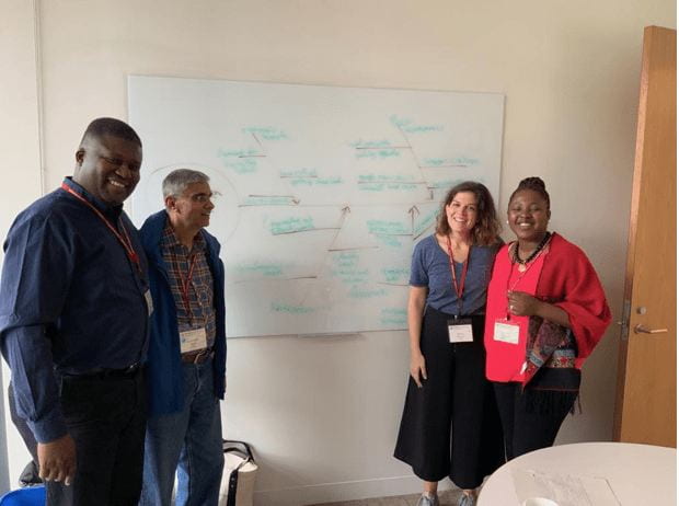 a group photograph in front of a white board