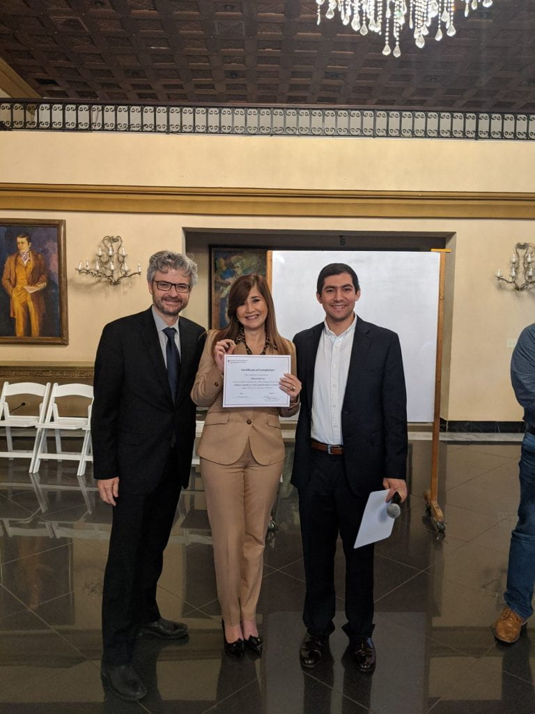 Participant posing with certificate alongside Matt Andrews and Danny Barjum