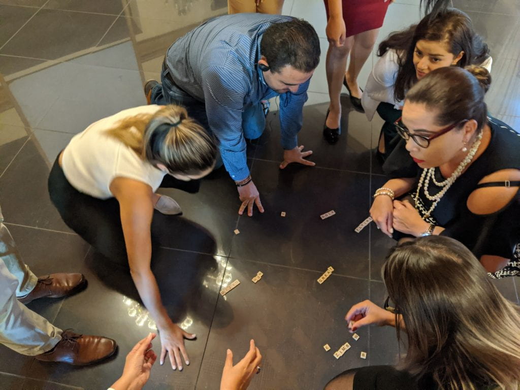 Participants creating words with scrabble pieces on the floor
