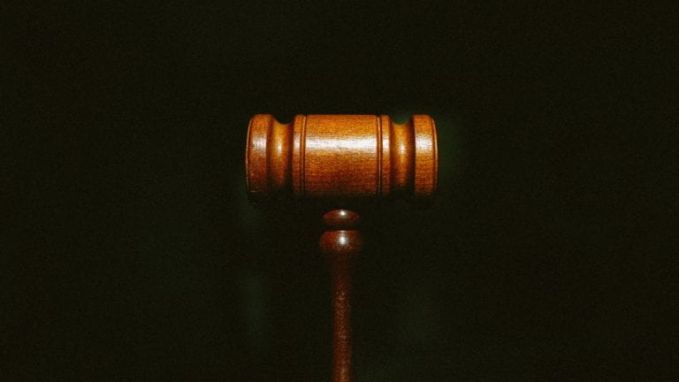 Gavel against black background to depict legal concept