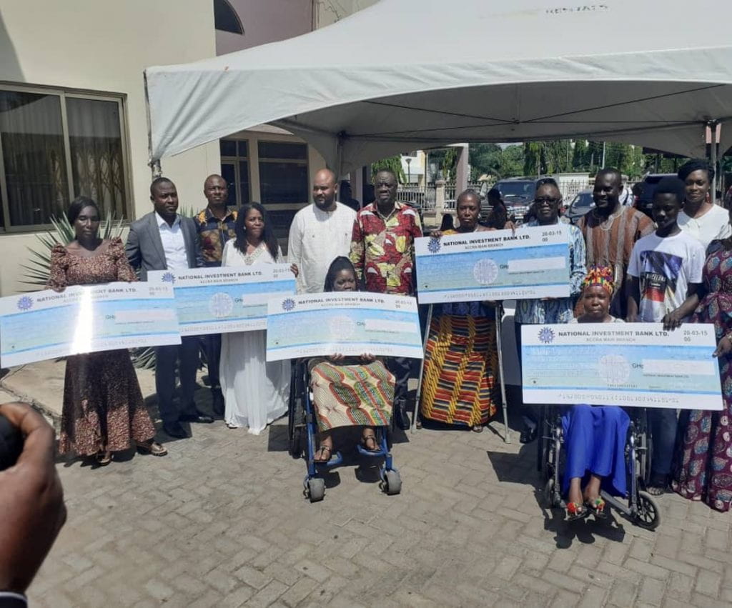 A group of people holding large checks