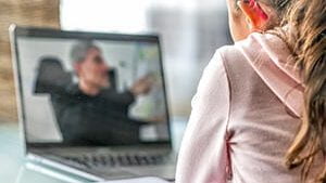 A student looking at a laptop and learning remotely