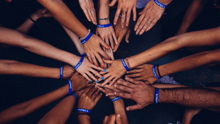 Arms outstretched toward center in team huddle