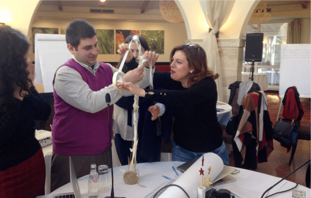 Participants collaborating on an activity to build a tall structure out of masking tape