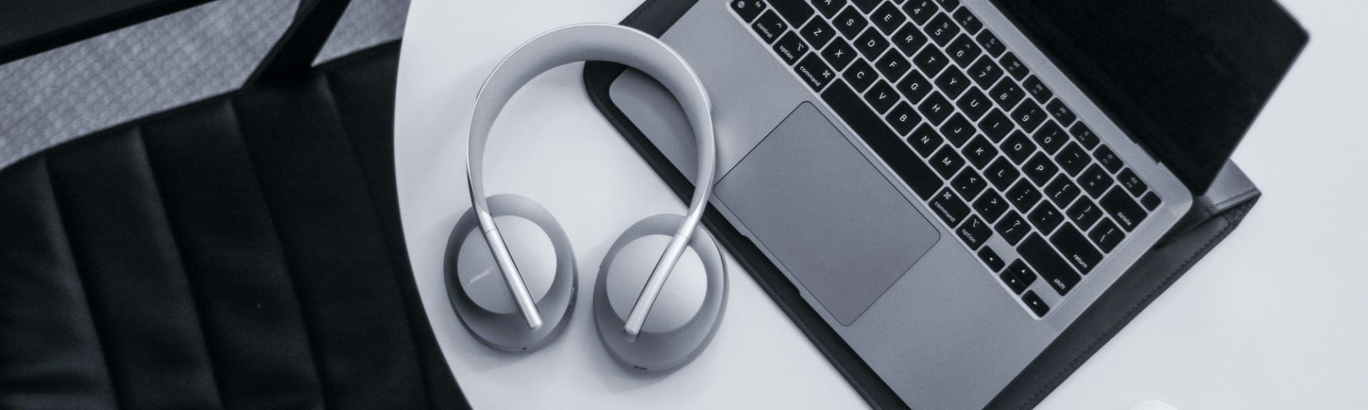 Open laptop on table with silver headphones
