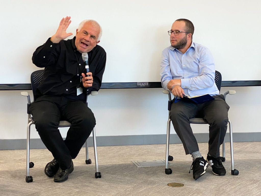 Lant Pritchett speaking with Dan Honig seated adjacent