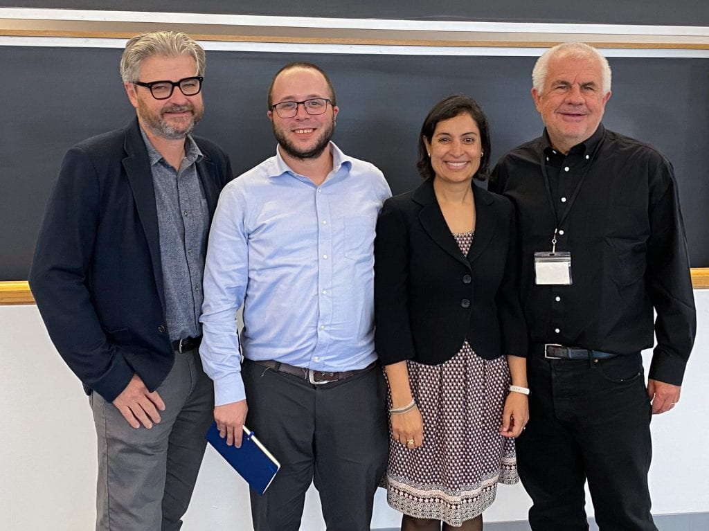 Matt Andrews, Lant Pritchett, Dan Honig, and Salimah Samji smiling in front of chalkboards