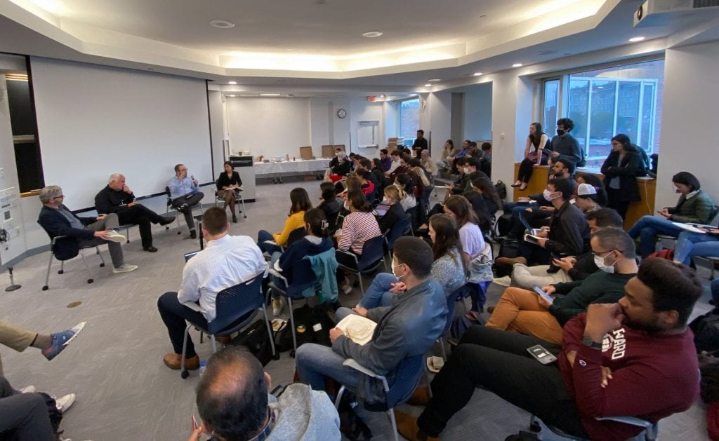 Matt Andrews, Lant Pritchett, Dan Honig (speaking with microphone), and Salimah Samji presenting with students in event space