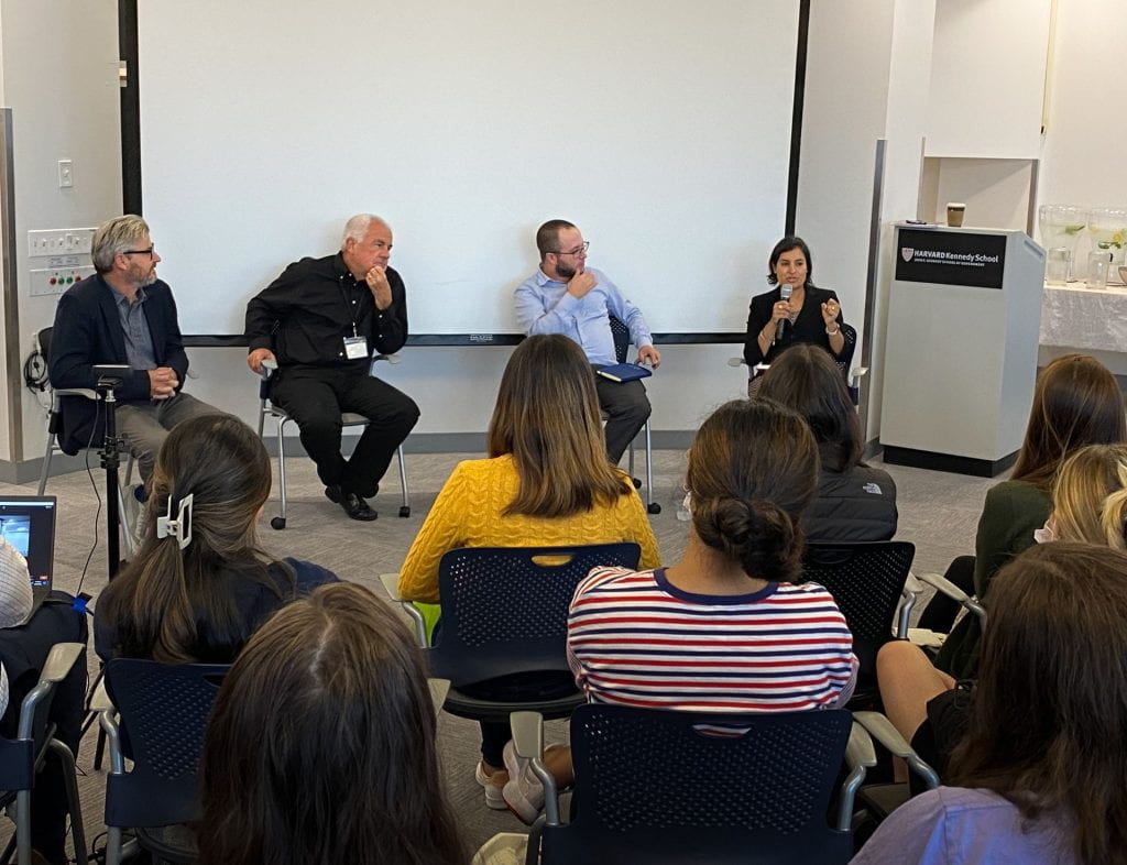 Matt Andrews, Lant Pritchett, Dan Honig, and Salimah Samji (holding microphone) presenting with students in foreground