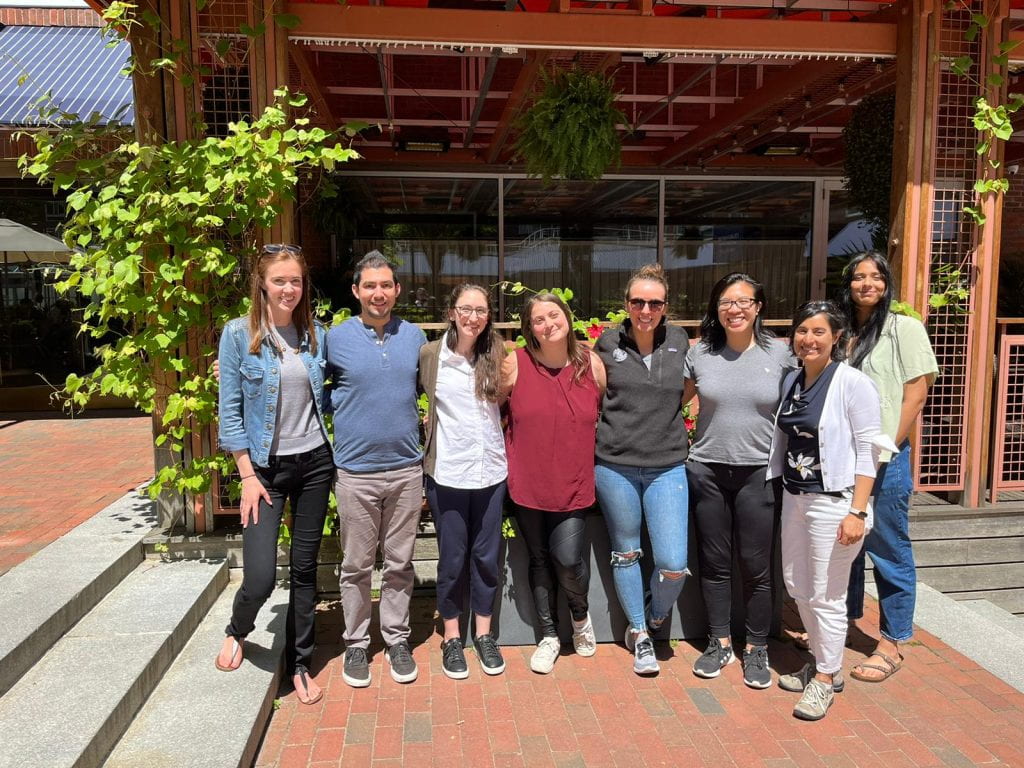 Group photo standing outdoors in front of a restaurant