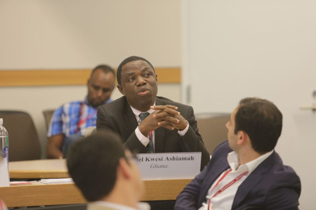 Participant sharing his thoughts with students onlooking
