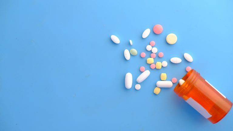 A prescription bottle with pills spilling out