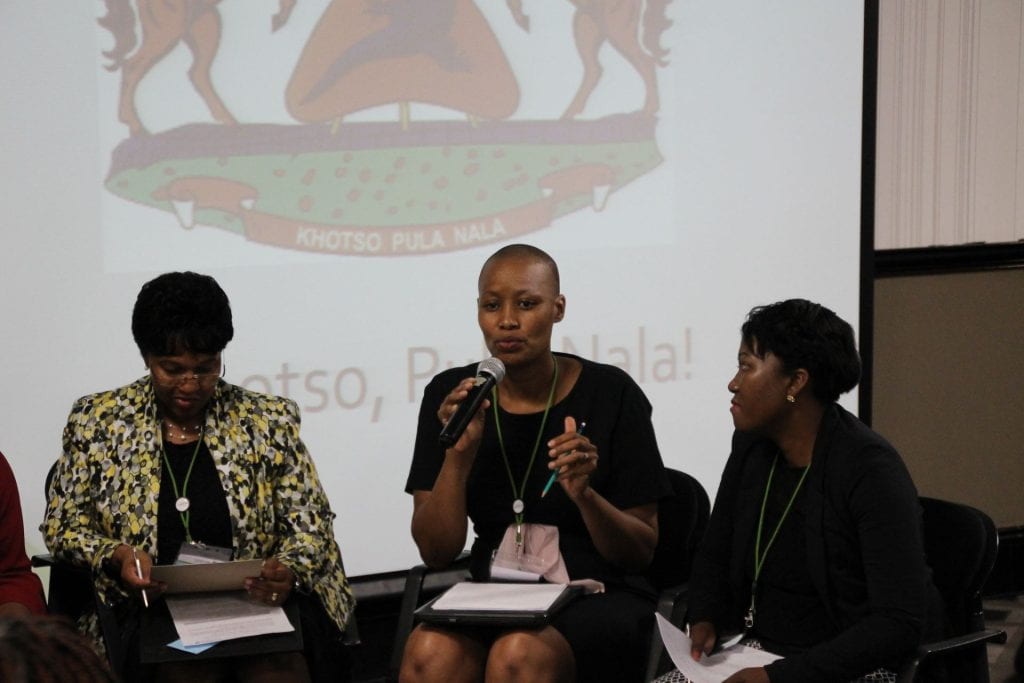 Lesotho team participant presenting with teammates on either side