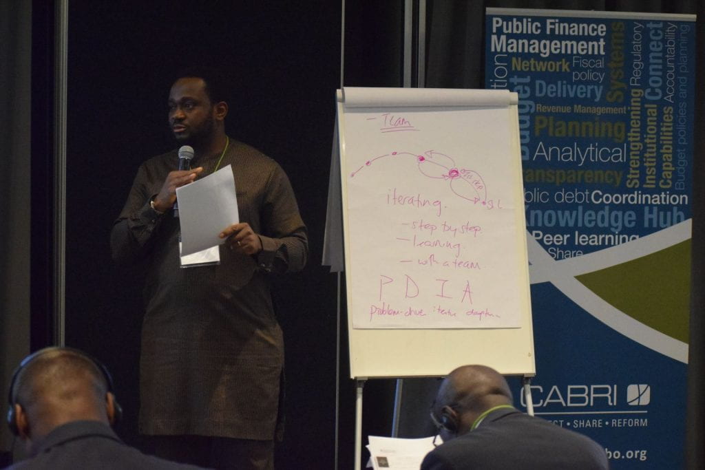 Nigeria team presenting. PDIA written on whiteboard behind.