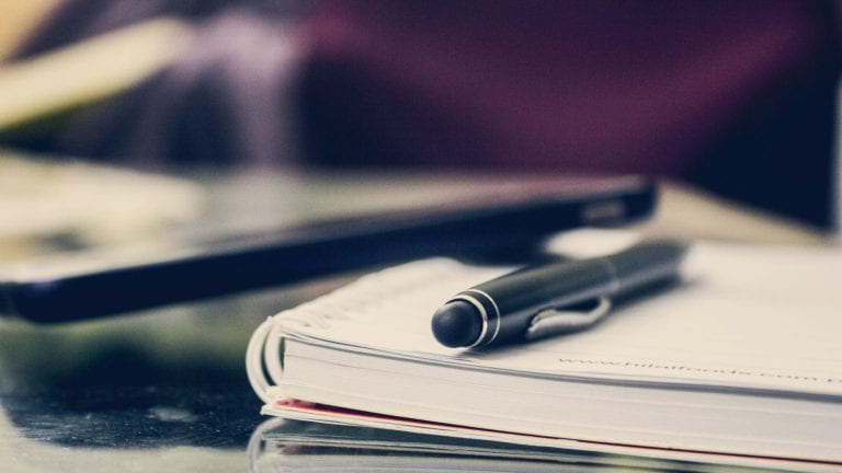 close-up of notebook and pen on desk