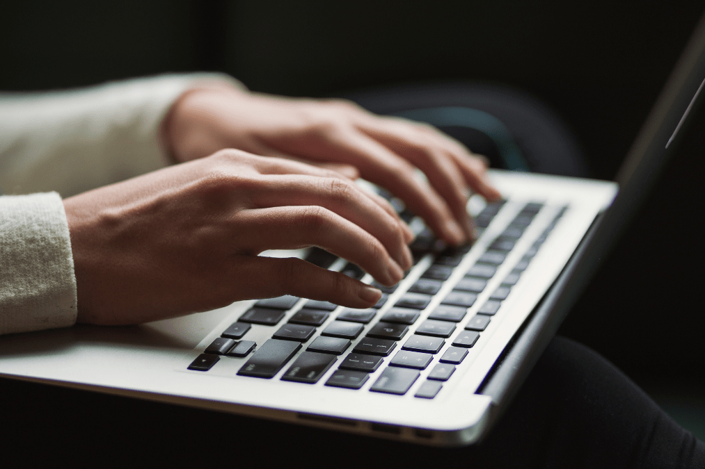 An open laptop with a person typing