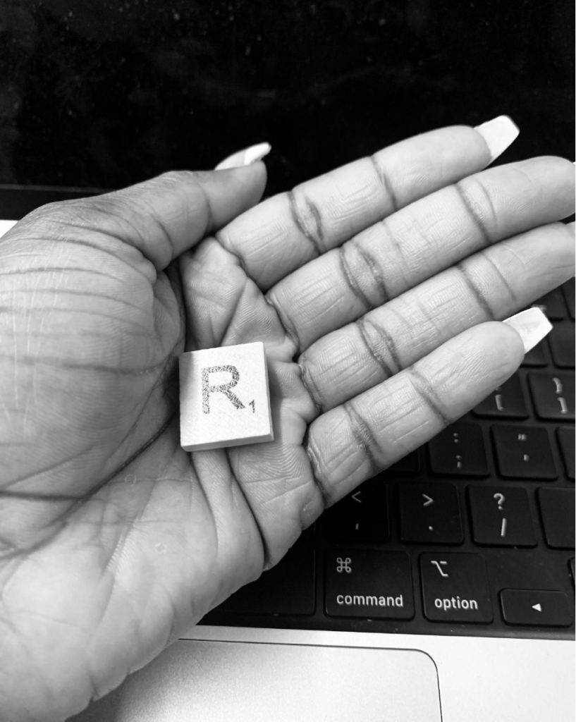 Scrabble piece in open hand