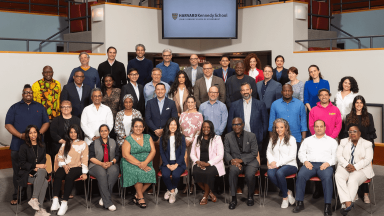 Group photo of the IPP class standing in the Kennedy Forum