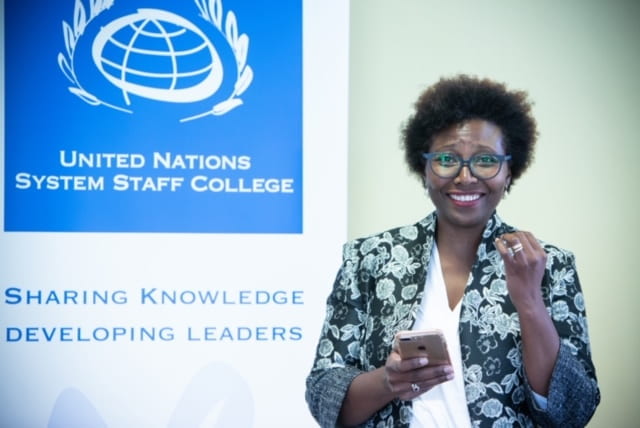woman standing in front of a United Nations System Staff College banner