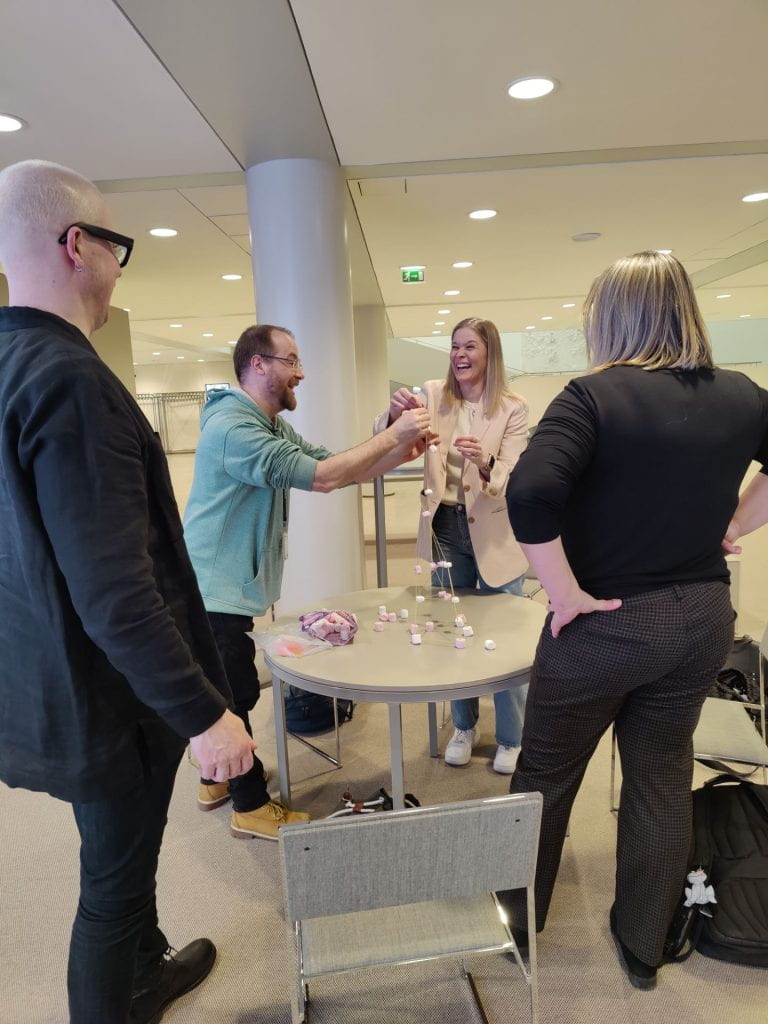 Participants creating a sculpture using marshmallows and sticks