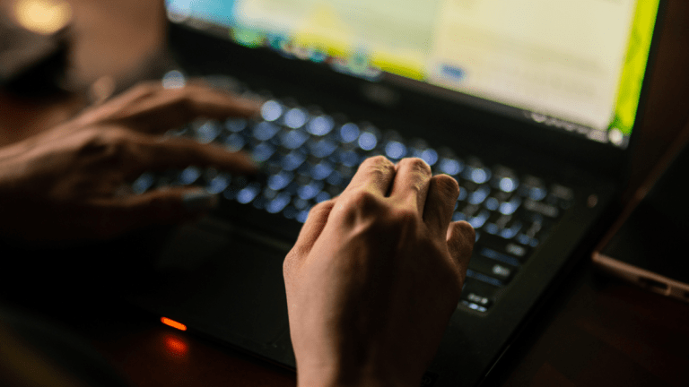 Hands typing on laptop