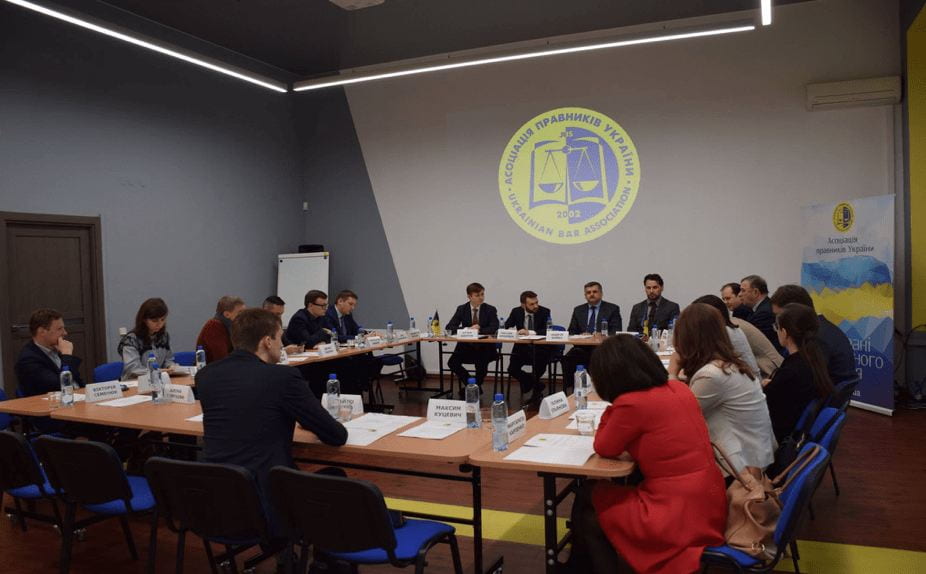 a large group around a meeting room table