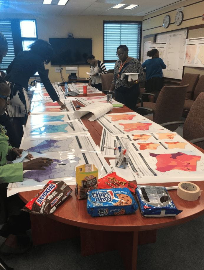 people around a table looking at maps