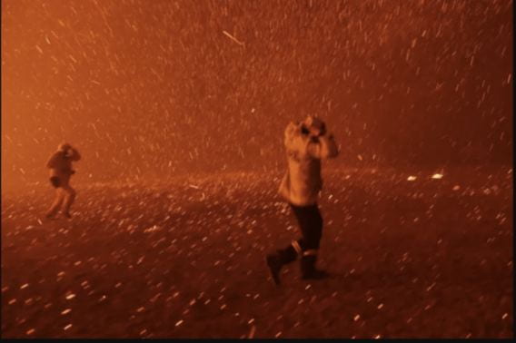 an image of two individuals running from fires