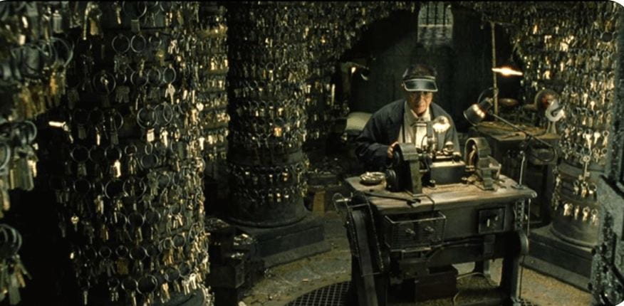 A locksmith in a dark room surrounded by hundreds of keys