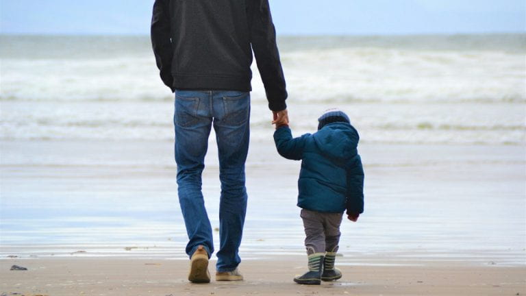 A father holding child's hand