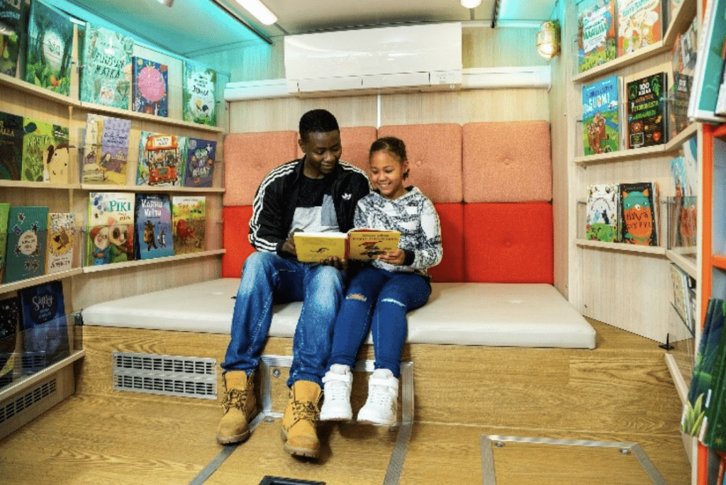 2 children reading in a library