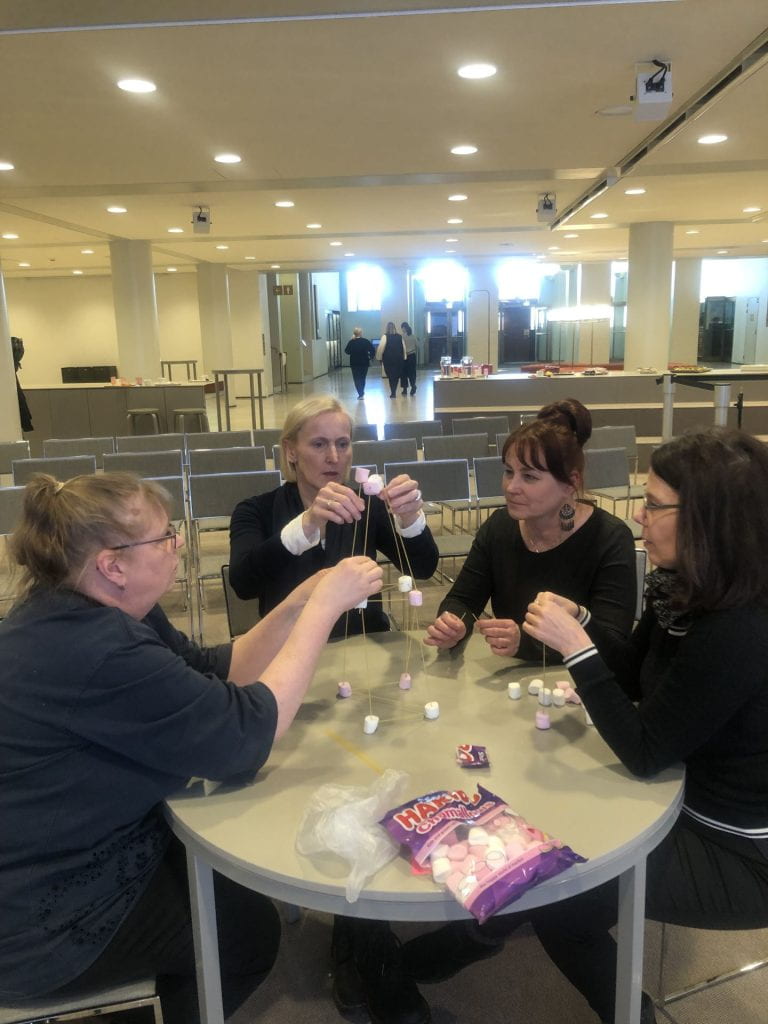 Team building a structure with marshmallows and sticks
