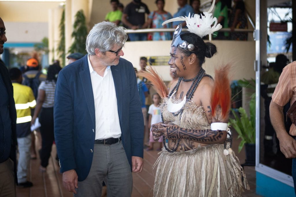 Matt Andrews speaking with a woman in traditional PNG dress
